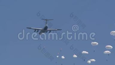 一支由军人组成的伞兵分队从飞机上跳下来，顶着蓝天